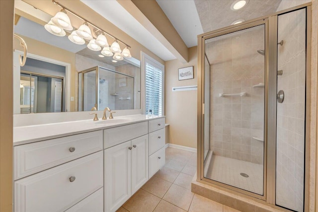 bathroom featuring tile patterned floors, a shower stall, vanity, and baseboards