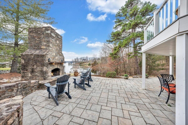 view of patio / terrace with a balcony and an outdoor stone fireplace