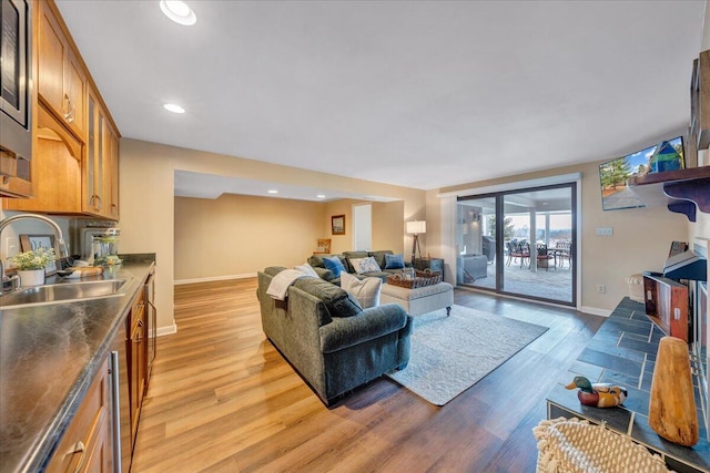 living room featuring recessed lighting, light wood-style floors, and baseboards