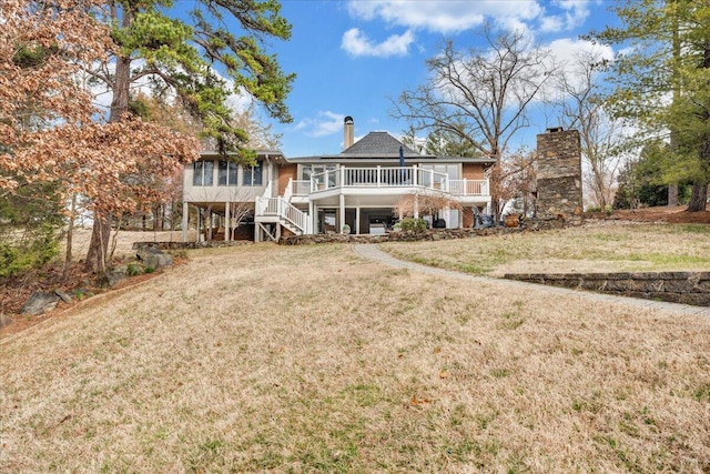 back of property featuring a lawn, a chimney, and stairs