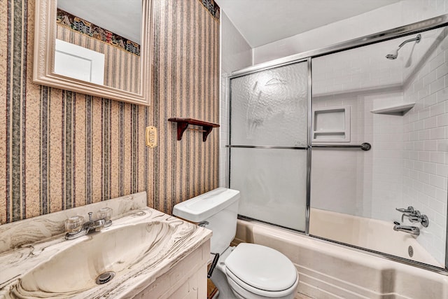 full bathroom with enclosed tub / shower combo, vanity, and toilet