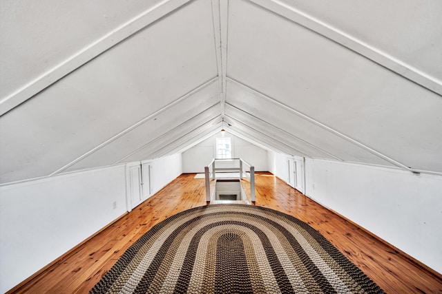 additional living space with lofted ceiling and light hardwood / wood-style flooring