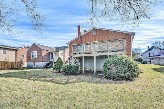 back of house featuring a lawn and a deck