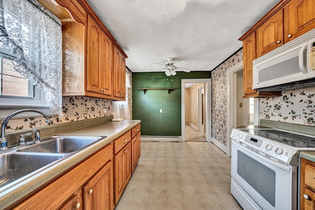 kitchen featuring sink, white appliances, ceiling fan, and a baseboard heating unit