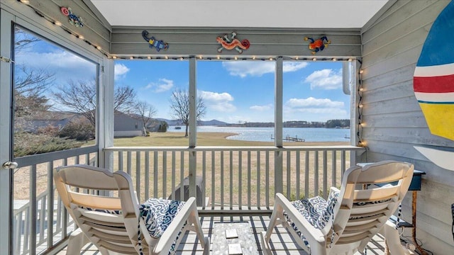 unfurnished sunroom featuring a water view