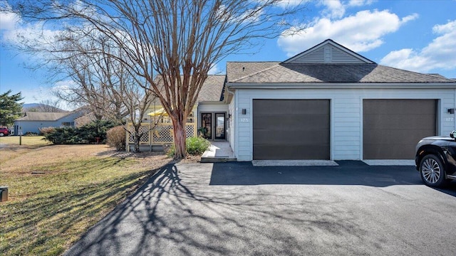 single story home with a garage and a front lawn