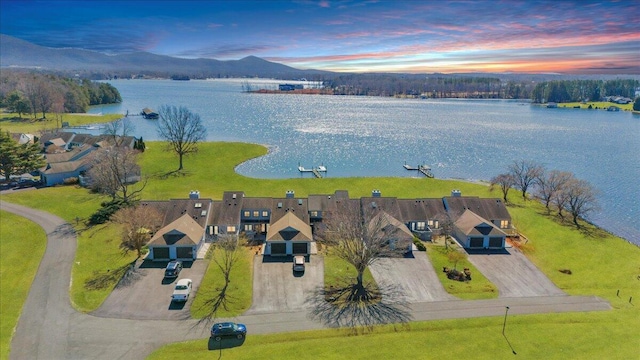 aerial view at dusk featuring a water and mountain view