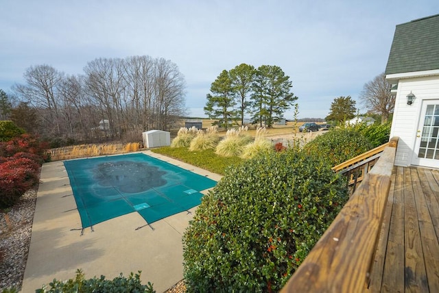 view of swimming pool with a wooden deck and a shed