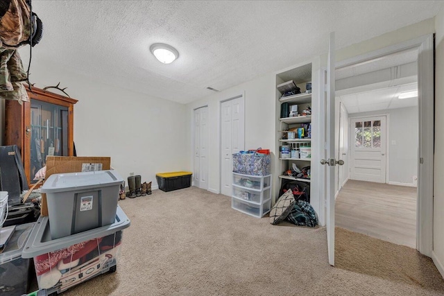 misc room featuring light carpet and a textured ceiling