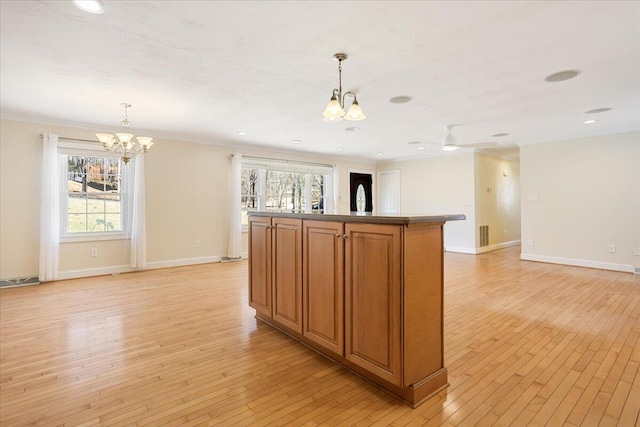 kitchen featuring brown cabinetry, open floor plan, and light wood-style flooring