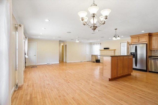 kitchen featuring light wood-style flooring, open floor plan, appliances with stainless steel finishes, a center island, and an inviting chandelier