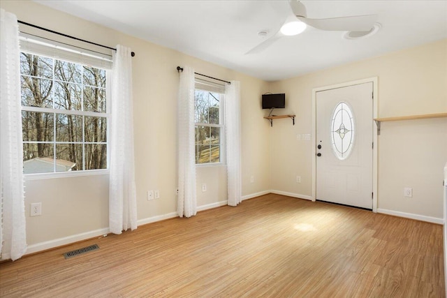 foyer with baseboards, visible vents, light wood-style flooring, and a ceiling fan