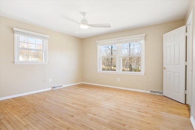 unfurnished bedroom with light wood finished floors, multiple windows, and visible vents