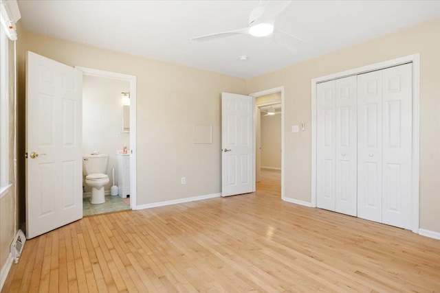 unfurnished bedroom featuring ensuite bathroom, a ceiling fan, baseboards, a closet, and light wood finished floors