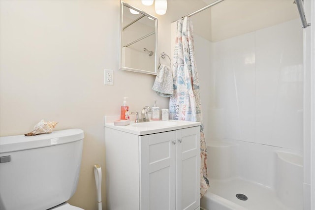 bathroom with a shower stall, toilet, and vanity