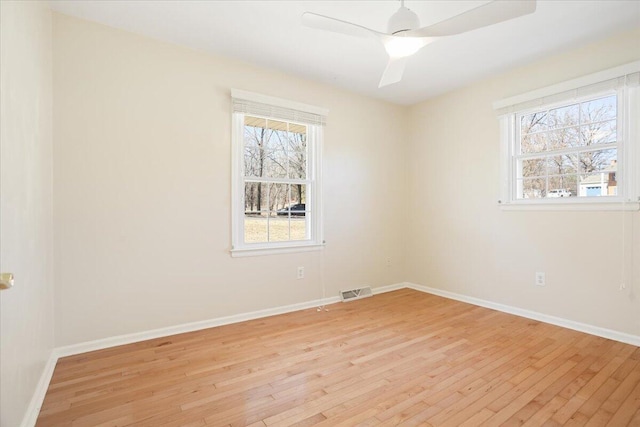 empty room featuring a ceiling fan, light wood-style flooring, and baseboards