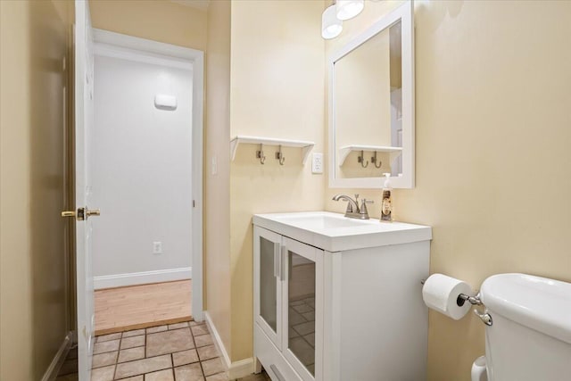 bathroom featuring tile patterned flooring, baseboards, vanity, and toilet