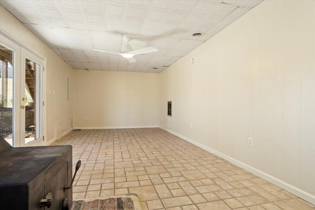 spare room with visible vents, a ceiling fan, and baseboards