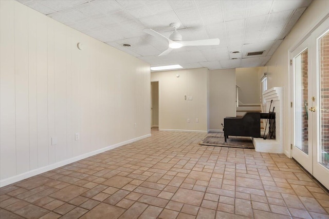 empty room with a ceiling fan, visible vents, stairway, and baseboards