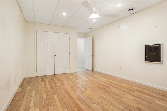 empty room with baseboards, visible vents, a ceiling fan, light wood-style flooring, and a paneled ceiling