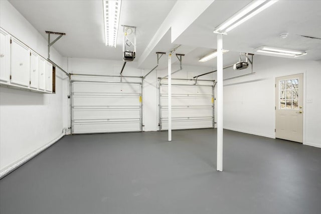 garage with baseboards and a garage door opener