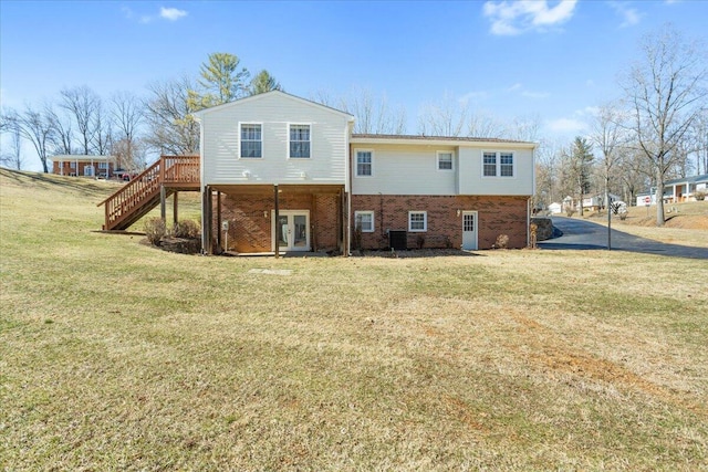 rear view of house with stairway, a yard, french doors, central AC, and brick siding