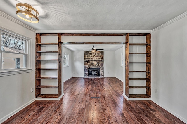 unfurnished living room with crown molding, a fireplace, dark hardwood / wood-style flooring, and a textured ceiling