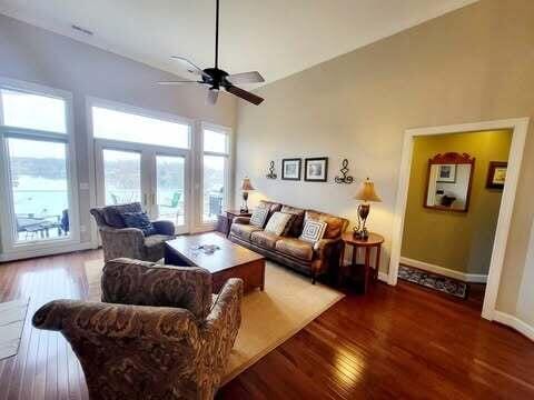 living room with ceiling fan, high vaulted ceiling, and hardwood / wood-style floors