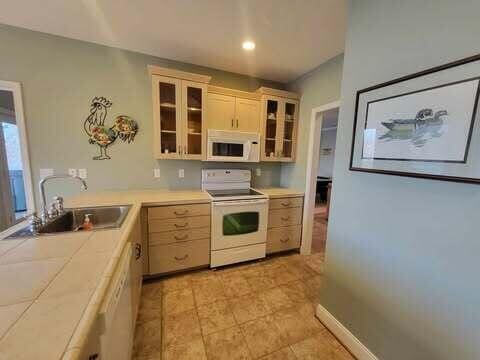 kitchen featuring sink, light brown cabinets, and white appliances