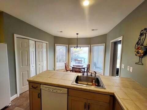 kitchen featuring sink, tile countertops, white appliances, and decorative light fixtures