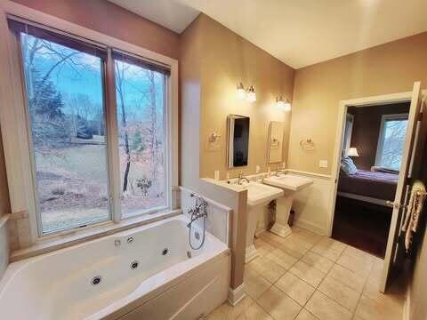 bathroom featuring tiled tub and tile patterned floors