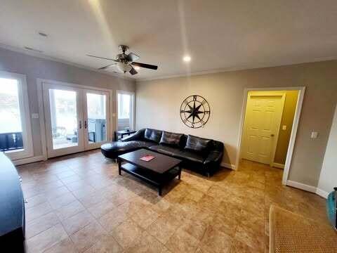 living room with crown molding, ceiling fan, and french doors