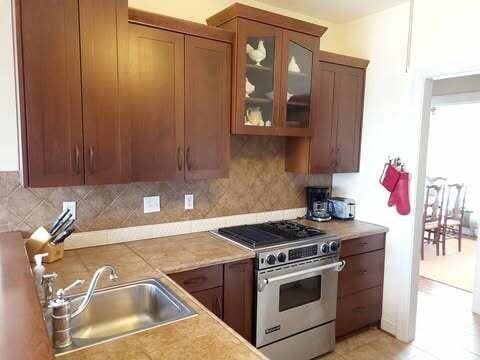 kitchen featuring sink, stainless steel stove, and decorative backsplash