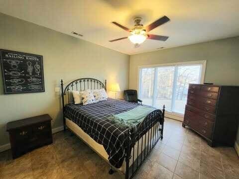 tiled bedroom featuring ceiling fan