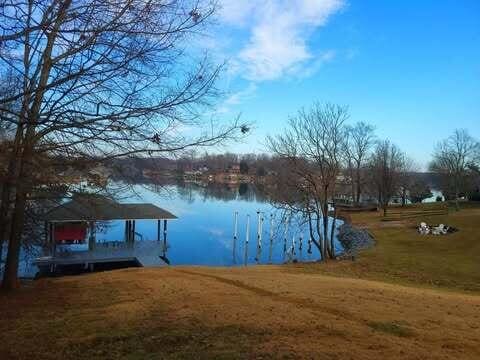 view of dock featuring a water view and a lawn