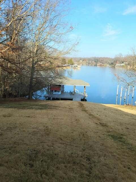 view of dock featuring a water view and a lawn