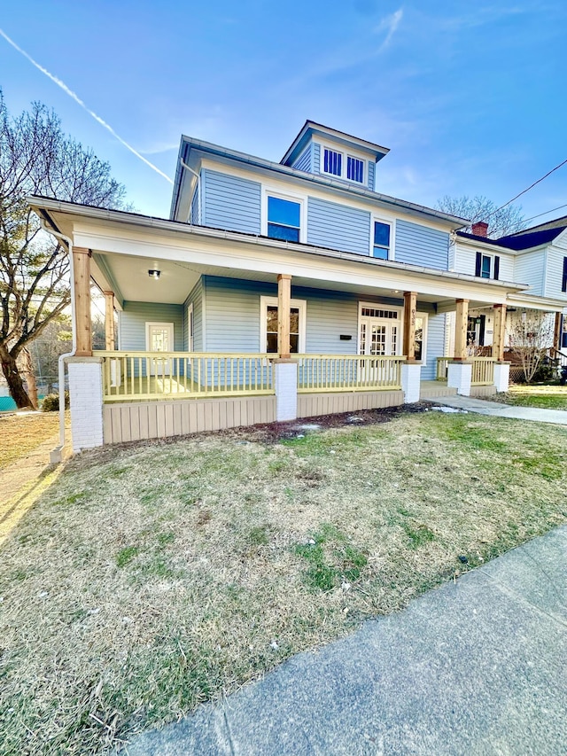 american foursquare style home with a front yard and french doors