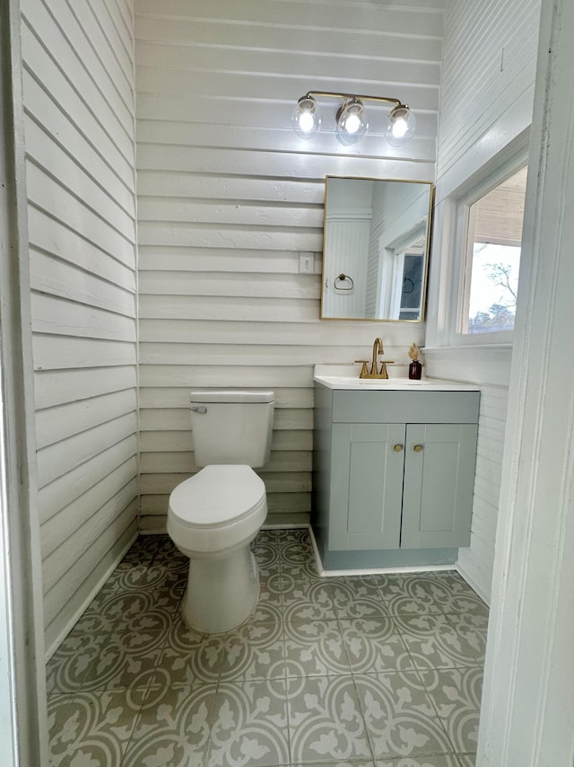 half bathroom with vanity, toilet, and tile patterned floors