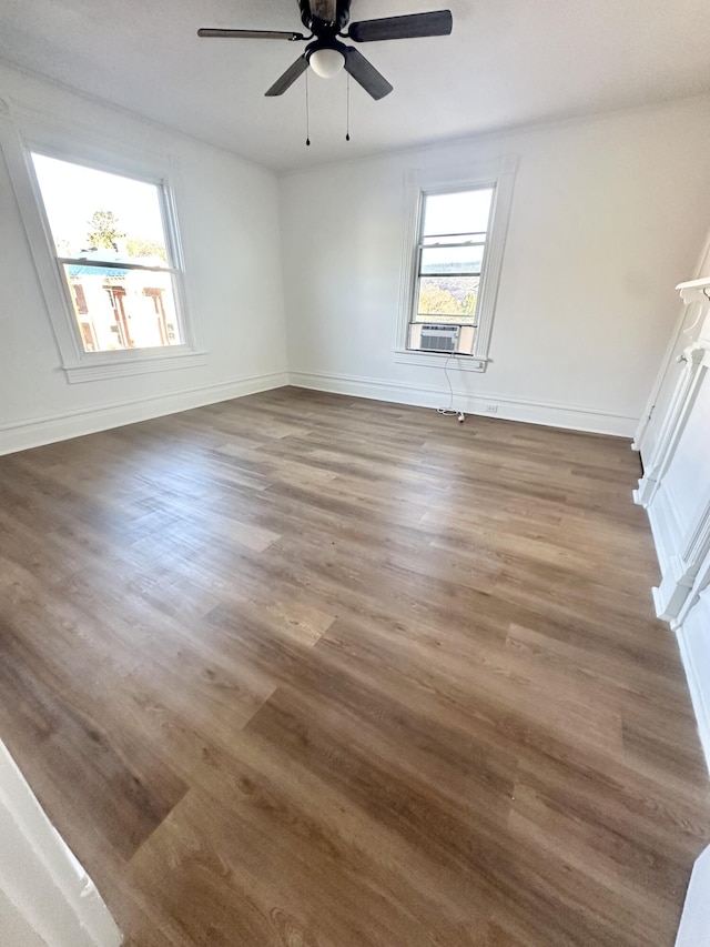 unfurnished room featuring dark wood-type flooring, a wealth of natural light, and cooling unit