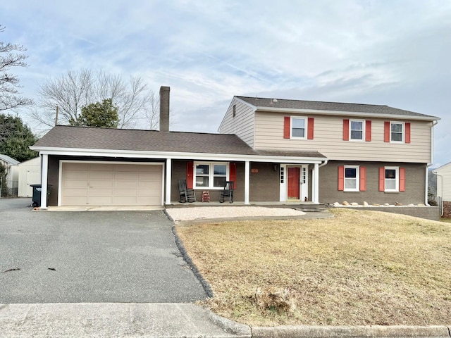 view of front facade featuring a garage, a front lawn, and a porch