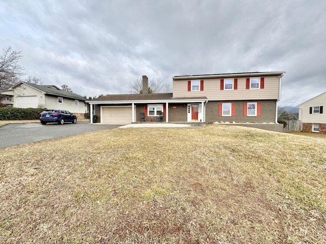 front of property with a porch, a garage, and a front yard