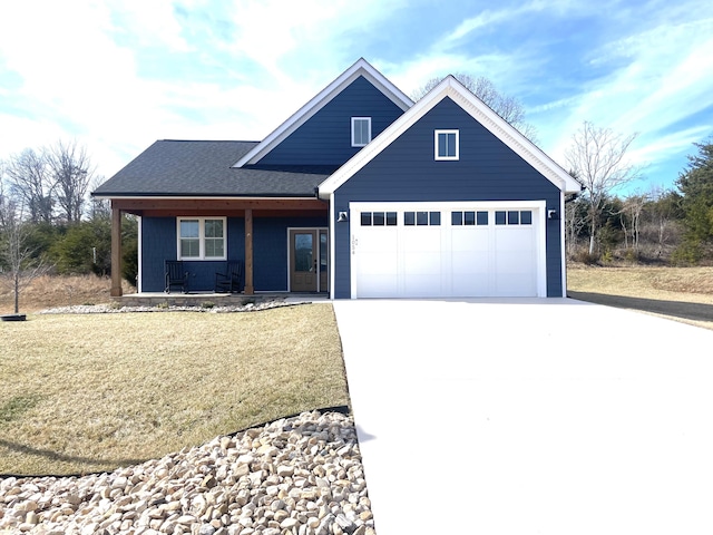 view of front of house featuring a garage, a front yard, and covered porch