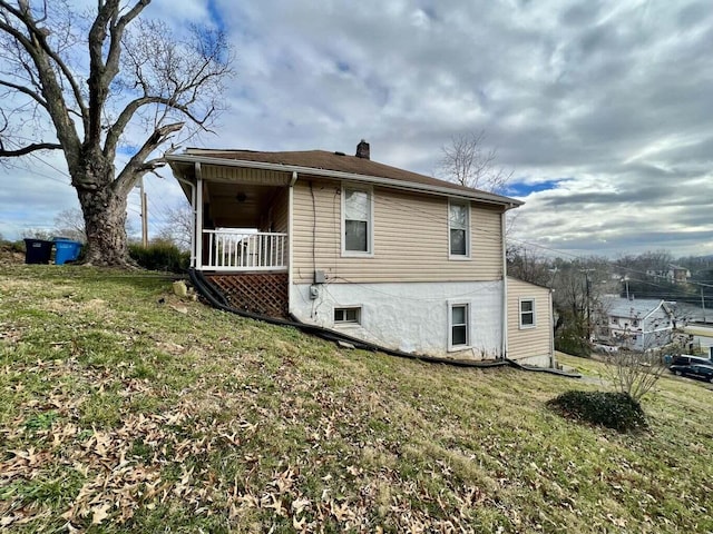 view of property exterior with a porch and a yard