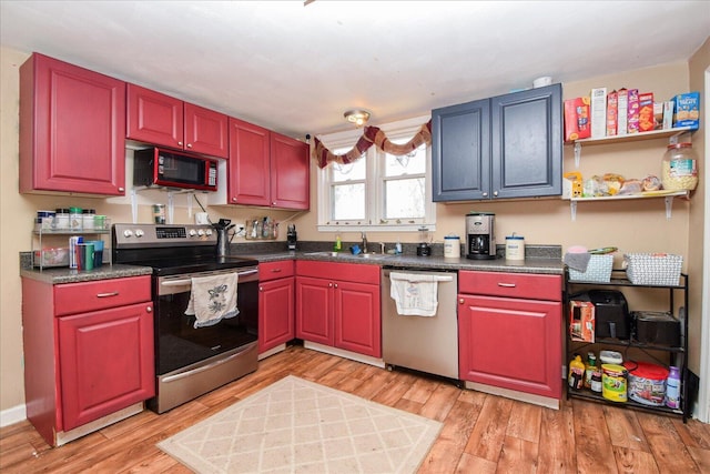 kitchen with light wood-type flooring, appliances with stainless steel finishes, and sink