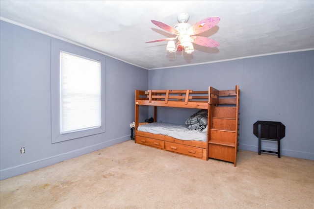 carpeted bedroom featuring ceiling fan and ornamental molding