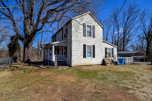 exterior space with a carport, a porch, and a front yard