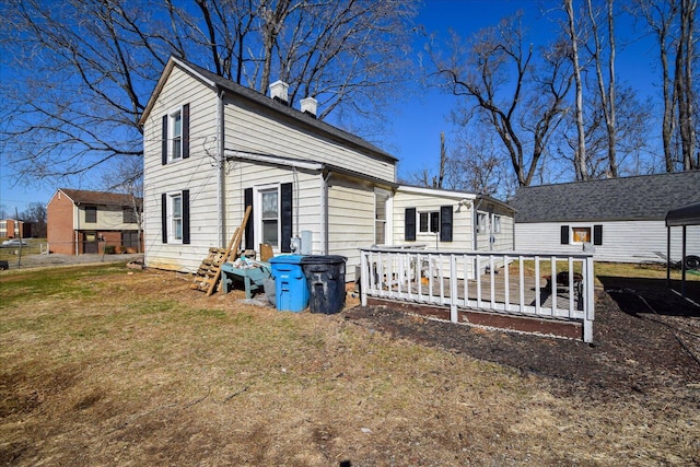 rear view of house with a deck and a lawn