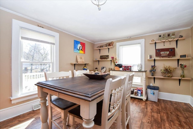 dining space featuring dark hardwood / wood-style flooring and crown molding