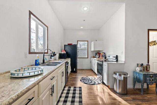 kitchen with appliances with stainless steel finishes, sink, dark wood-type flooring, and white cabinets