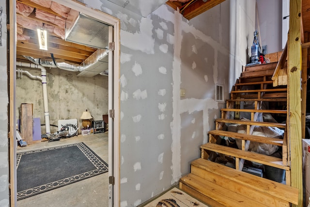 staircase featuring concrete floors